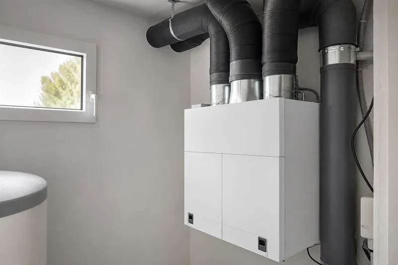 Un recuperador de calor con los conductos aislados en el cuarto de instalaciones de una vivienda